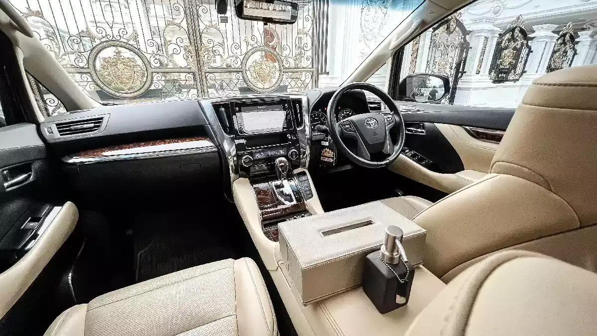 Alphard front cabin with cream leather, wood trim and a console tissue box