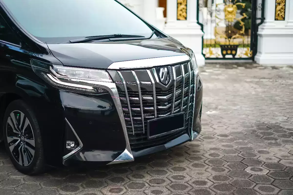 Close-up of the chrome grille and headlight on a black Toyota Alphard