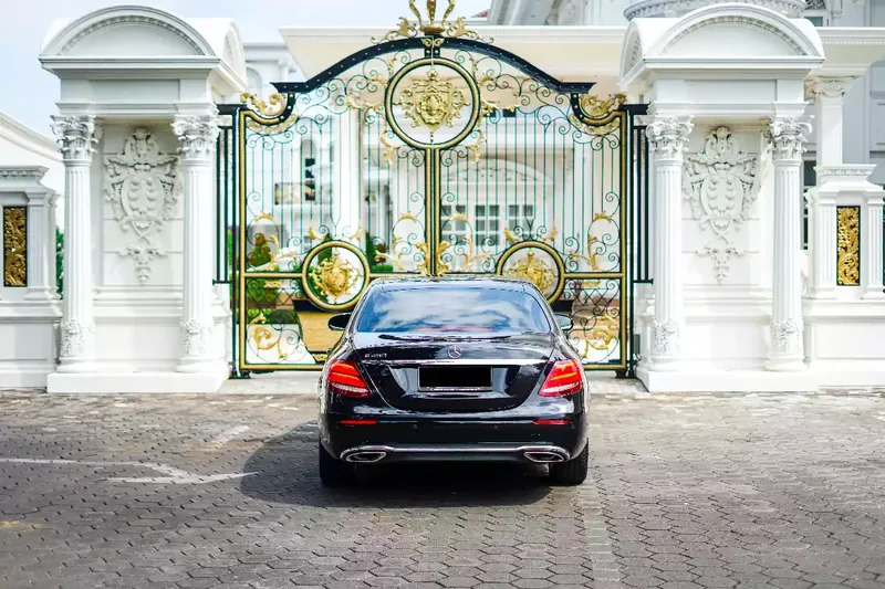 Black Mercedes-Benz E-Class saloon at a gate