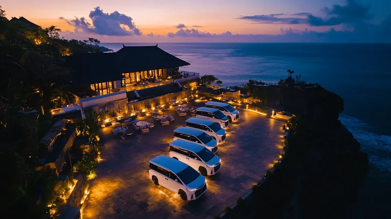 Row of white MPVs lined up at a clifftop venue at dusk