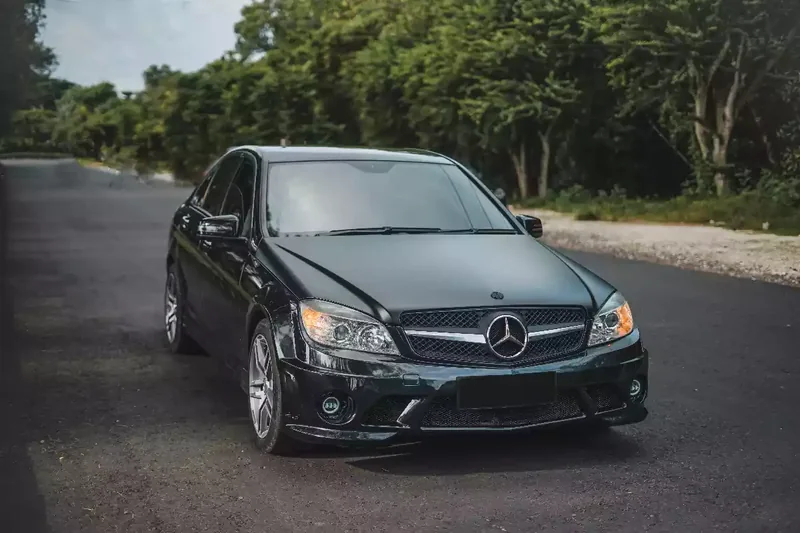 Black Mercedes-Benz E-Class saloon photographed head-on at a gate