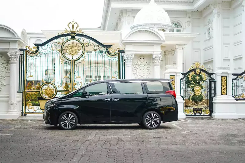 Black Toyota Alphard waiting side-on at a gate
