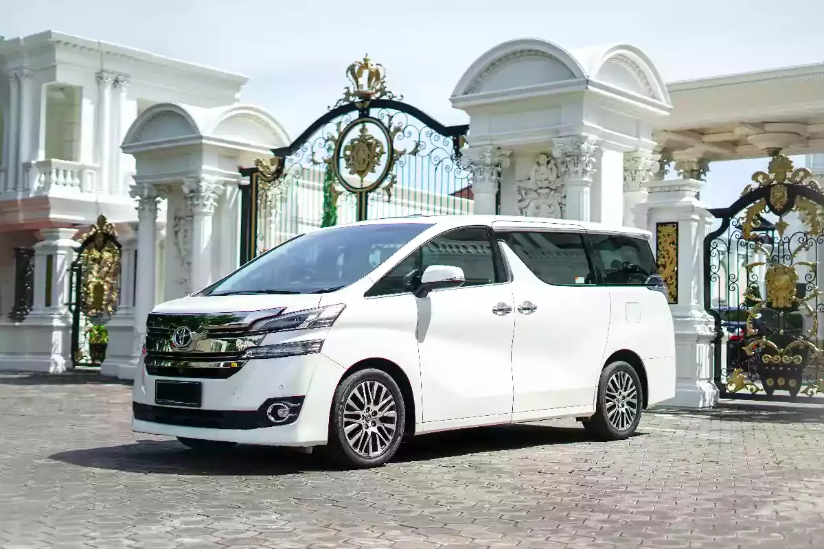 White Toyota Vellfire waiting side-on at an ornate gate