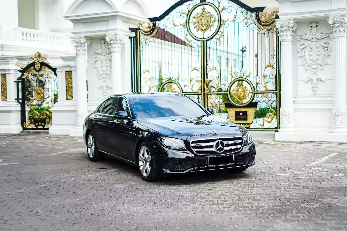 Black executive saloon photographed front three-quarter at an ornate gate
