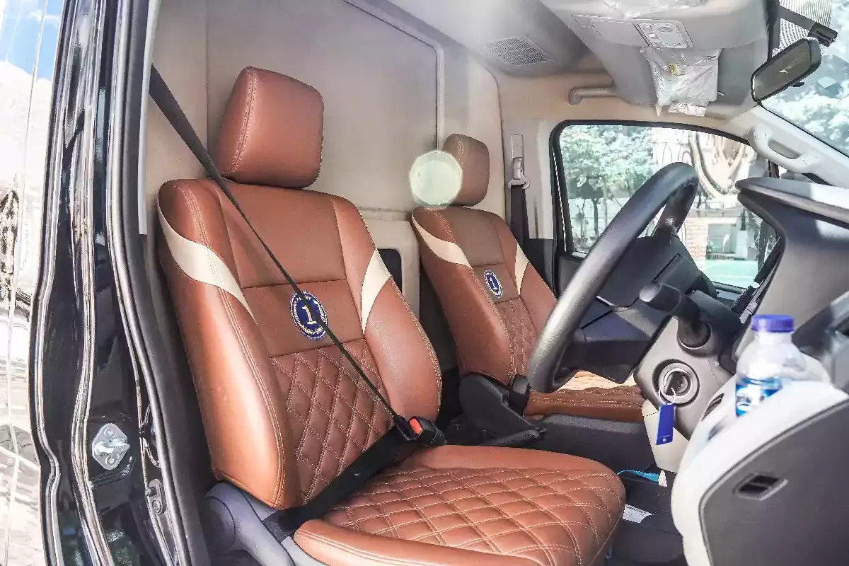 Quilted tan leather front seats and dashboard inside a Toyota Hiace Premio