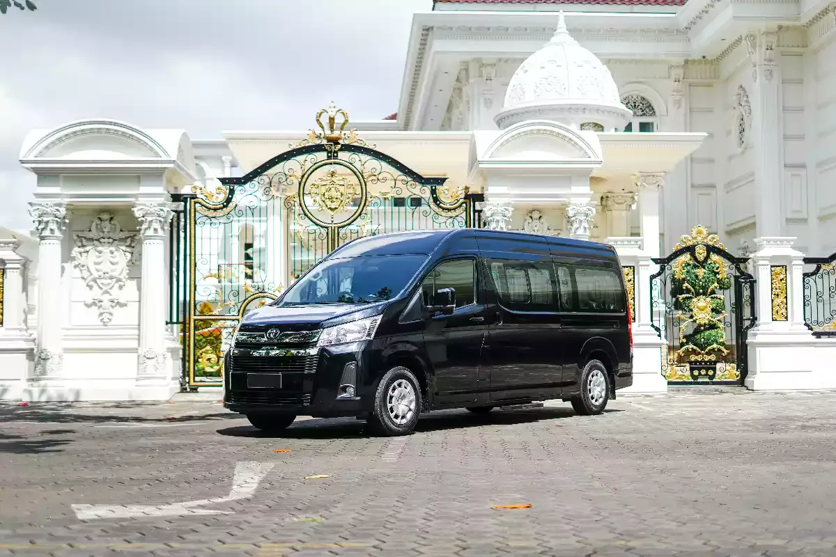Black Toyota Hiace Premio photographed side-on at an ornate white gate